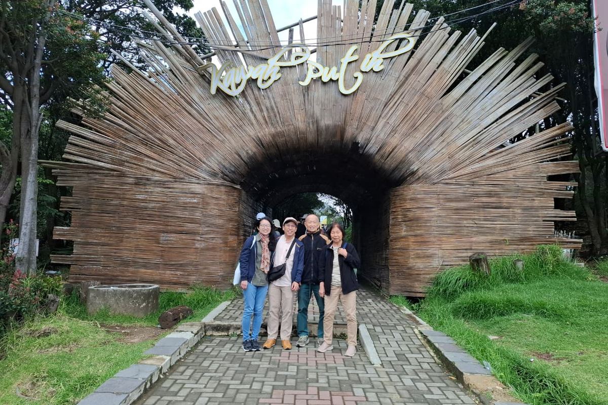 Rombongan tamu memasuki lorong gua berlatar bambu